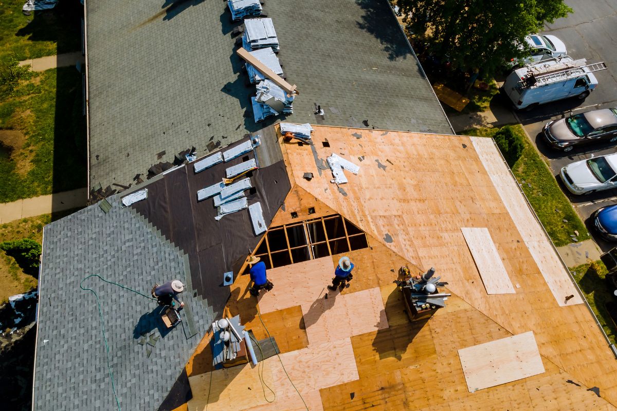 A group of roofing contractors working on a residential roof in Washington, D.C., showcasing tools and safety equipment.